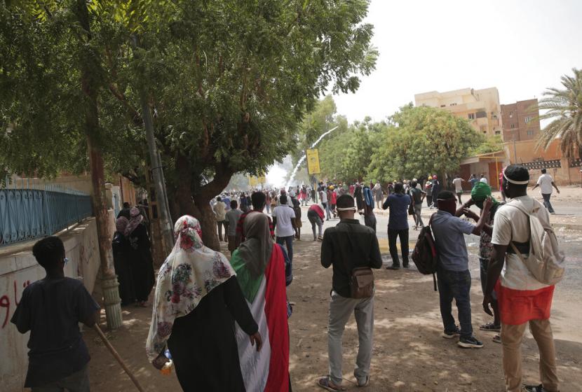 Para pengunjuk rasa bentrok dengan pasukan keamanan saat mereka menembakkan gas air mata untuk mencegah mereka berbaris menuju istana presiden selama demonstrasi menuntut pemerintahan sipil, di Khartoum, Sudan, Kamis, 19 Mei 2022.