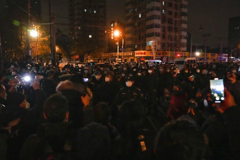  Para pengunjuk rasa bentrok dengan polisi selama protes di Beijing, Ahad, 27 November 2022. Para pengunjuk rasa yang marah dengan langkah-langkah anti-virus yang ketat menyerukan agar pemimpin kuat China itu mengundurkan diri, teguran yang belum pernah terjadi sebelumnya ketika pihak berwenang di setidaknya delapan kota berjuang untuk menekan demonstrasi pada Minggu itu. merupakan tantangan langsung yang langka terhadap Partai Komunis yang berkuasa.