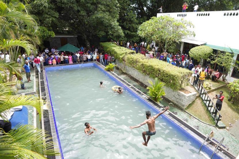 Para pengunjuk rasa berenang ketika para penonton menunggu di kolam renang di kediaman resmi presiden sehari setelah diserbu di Kolombo, Sri Lanka, Minggu, 10 Juli 2022.