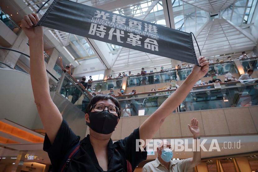 Para pengunjuk rasa dengan membawa sepanduk melakukan aksi protes di sebuah pusat perbelanjaan di Hong Kong, Selasa (9/6). Setahun sejak dimulainya protes anti-pemerintah Hong Kong, pemimpin kota Cina semi-otonom mengatakan bahwa semua pihak harus belajar dari kesulitan dan masa-masa sulit selama setahun terakhir.  