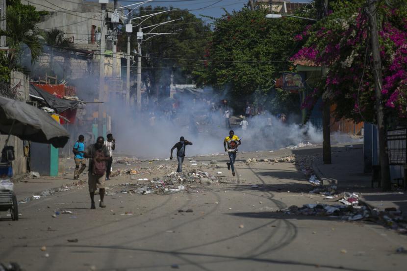 Para pengunjuk rasa dibubarkan oleh gas air mata yang dilemparkan oleh polisi saat demonstrasi menuntut pengunduran diri Perdana Menteri Ariel Henry di daerah Petion-Ville Port-au-Prince, Haiti, Senin, 3 Oktober 2022.