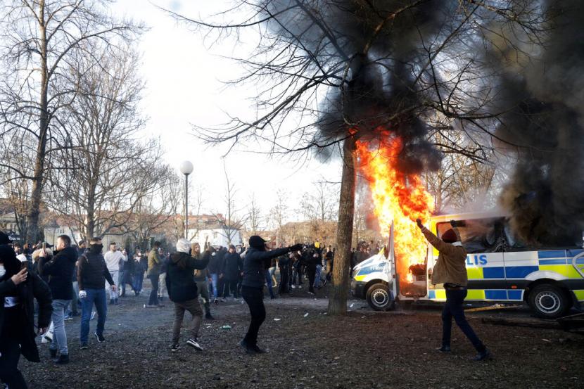Para pengunjuk rasa membakar bus polisi di taman Sveaparken di Orebro, Swedia, Jumat, 15 April 2022. Irak Panggil Dubes Swedia Setelah Demonstrasi Pembakaran Alquran