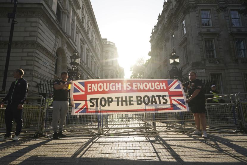 Para pengunjuk rasa membawa spanduk di depan protes Cukup Sudah di Whitehall, London, Rabu 31 Juli 2024, menyusul penusukan fatal tiga anak di klub liburan bertema Taylor Swift pada Senin di Southport.