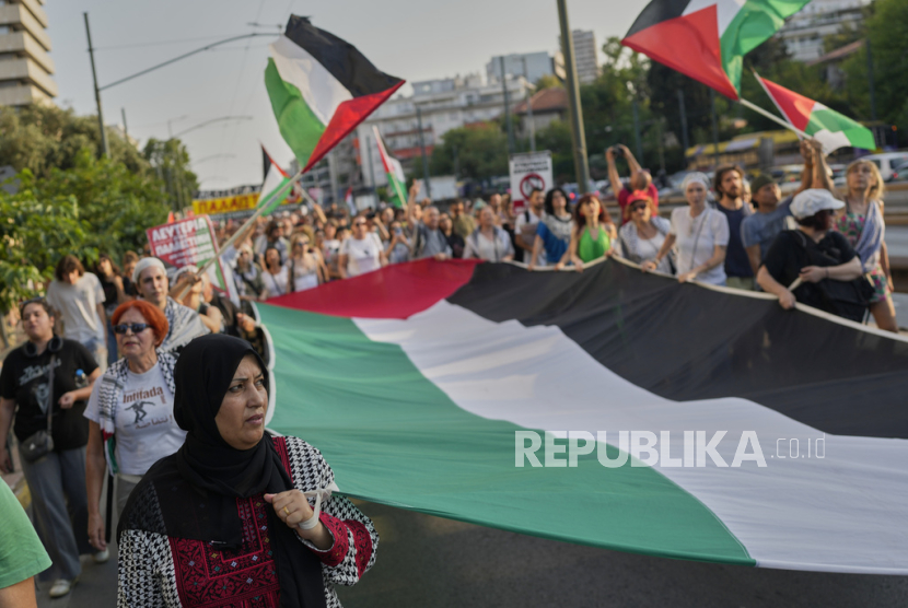 Para pengunjuk rasa membentangkan bendera Palestina berukuran raksasa dalam sebuah demonstrasi di Athena, Senin, 9 Juni 2025, sebagai bentuk dukungan terhadap rakyat Palestina di Gaza.