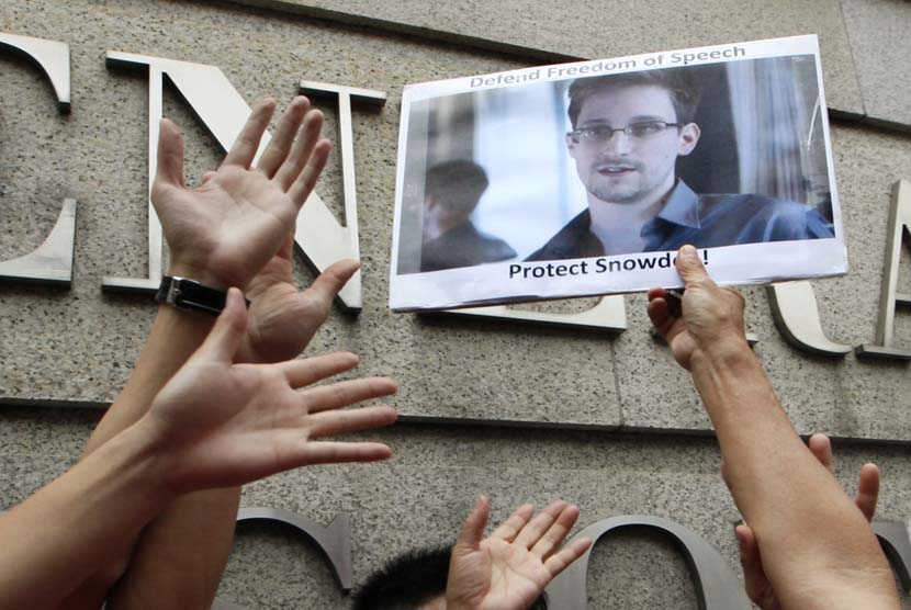  Para pengunjuk rasa memegang poster foto Edward Snowden, mantan karyawan CIA yang membocorkan informasi rahasia tentang program pengintaian AS, di luar gedung Konsulat Jenderal AS di Hong Kong, Kamis (13/6).    (AP/Kin Cheung)