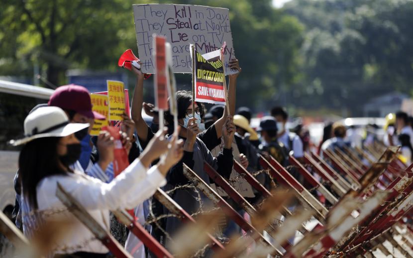 Para pengunjuk rasa memegang spanduk selama protes menentang kudeta militer di luar Kedutaan Besar China di Yangon, Myanmar, 13 Februari 2021. Orang-orang terus melakukan unjuk rasa di seluruh negeri meskipun ada perintah yang melarang pertemuan massal dan laporan peningkatan penggunaan kekuatan oleh polisi terhadap pengunjuk rasa anti-kudeta. Militer Myanmar merebut kekuasaan dan mengumumkan keadaan darurat selama satu tahun setelah menangkap Penasihat Negara Aung San Suu Kyi dan presiden Myanmar Win Myint dalam serangan dini hari pada 01 Februari.