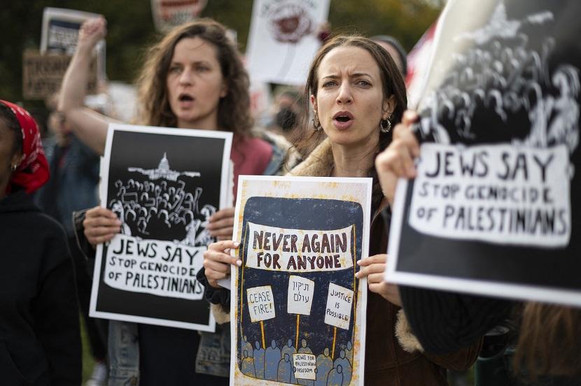 Para pengunjuk rasa mengangkat poster yang berisi kecaman terhadap operasi militer Israel di Gaza. Aksi unjuk tersebut digelar di Washington, DC, pada 18 Oktober 2023.