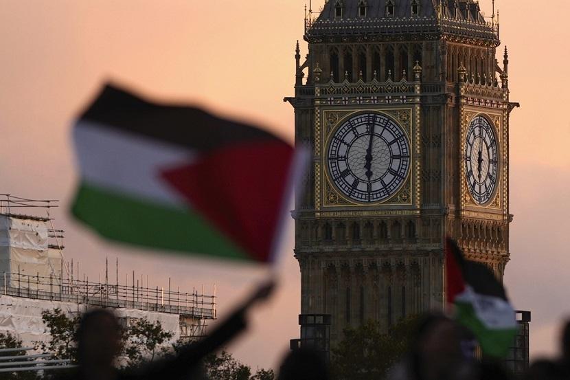Para pengunjuk rasa mengibarkan bendera Palestina.