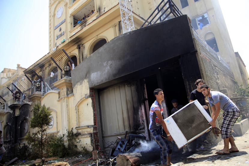 Para pengunjuk rasa menyerang dan menjarah markas Ikhwanul Muslimin di distrik Muqatam di Kairo, Senin (1/7).       (AP/Khalil Hamra)