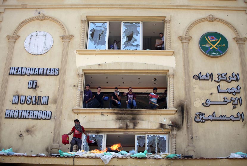 Para pengunjuk rasa menyerang dan merusak markas Ikhwanul Muslimin di distrik Muqatam di Kairo, Senin (1/7).       (AP/Khalil Hamra)