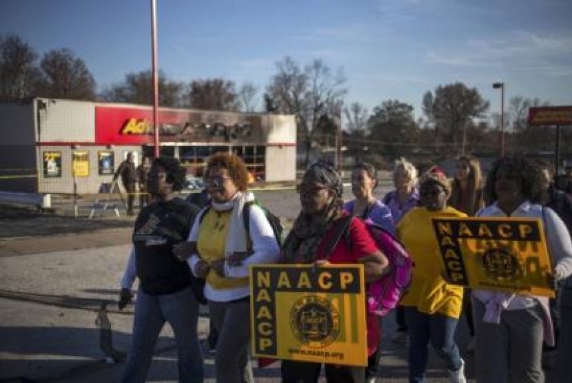 Para pengunjuk rasa menyuarakan dukungannya bagi Michael Brown, yang mati ditembak polisi berkulit putih, di Ferguson, AS.