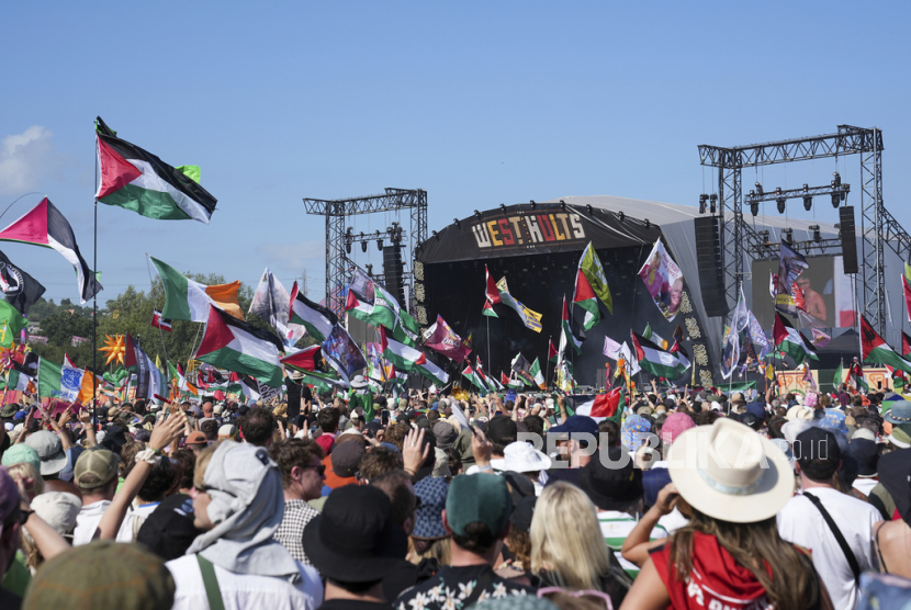 Para pengunjung festival menyaksikan penampilan trio hip-hop Kneecap dalam gelaran Festival Glastonbury di Worthy Farm, Somerset, Inggris, Sabtu, 28 Juni 2025. 