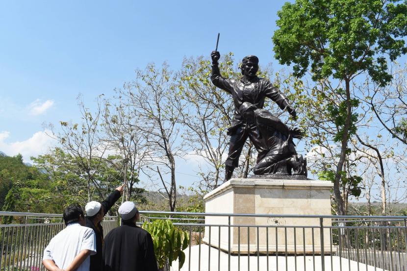 Para pengunjung melihat patung yang menggambarkan kekejaman PKI yang beraksi dalam geger Madiun 1948. Monumen di Kresek ini menjadi pengingat akan peristiwa historis yang kelam itu.