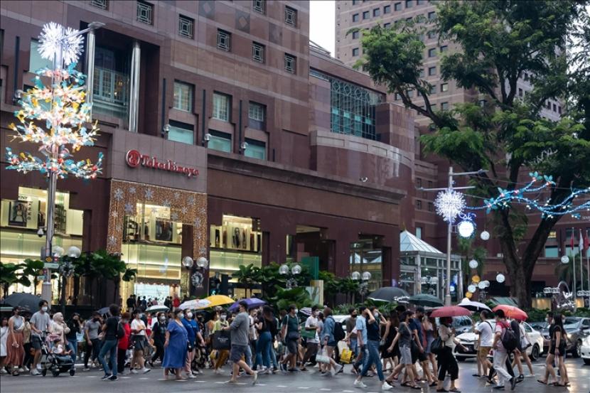 Para pengunjung memadati kawasan perbelanjaan Singapura dalam persiapan untuk musim perayaan selama pandemi virus korona (Covid-19) yang telah mencatat total lebih dari 58.000 kasus dan 29 kematian terkait di Singapura pada 12 Desember 2020. 