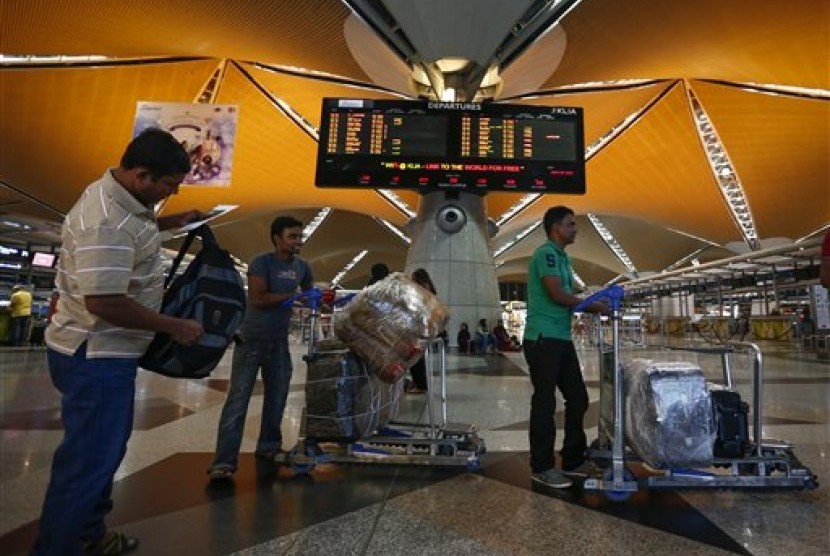Para penumpang mengantre masuk ke dalam pesawat di Bandara Internasional Kuala Lumpur, Malaysia.