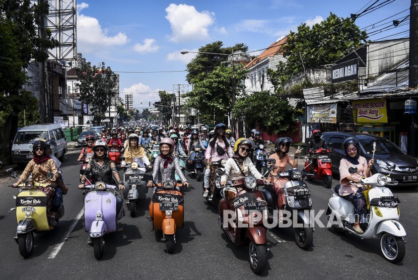 Para wanita dengan memakai kebaya mengendarai skuter vespa saat mengikuti kegiatan Indonesia Kartini Ride Vol II di kawasan Jalan Ir H Djuanda, Kota Bandung, Ahad (21/4).