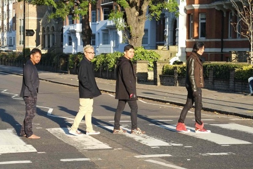 Para personel band Gigi melakukan adegan abbey road crossing yang dipopulerkan The Beatles