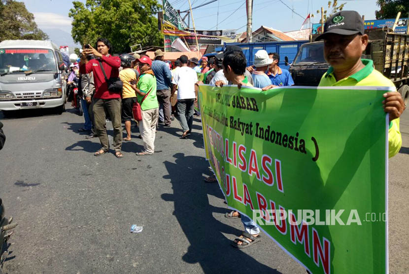 Para petani tebu yang tergabung dalam Andalan Petani Tebu Rakyat Indonesia (APTRI) Jabar menggelar aksi dengan menghadang truk pengangkut tebu dan membagikan gula kepada warga secara gratis di depan pintu masuk Pabrik Gula Sindanglaut, Kecamatan Lemahabang, Kabupaten Cirebon, Kamis (24/8). 