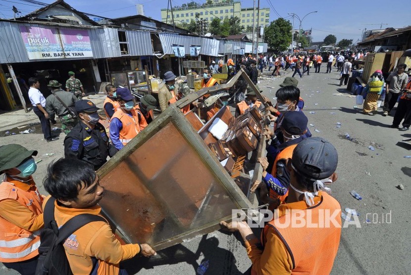 Para petugas membatu mengeluarkan barang-barak pada eksekusi lahan, PT Kereta Api Indonesia (KAI), Jl Stasiun Barat, Kota Bandung, Selasa (26/7). (Mahmud Muhyidin)