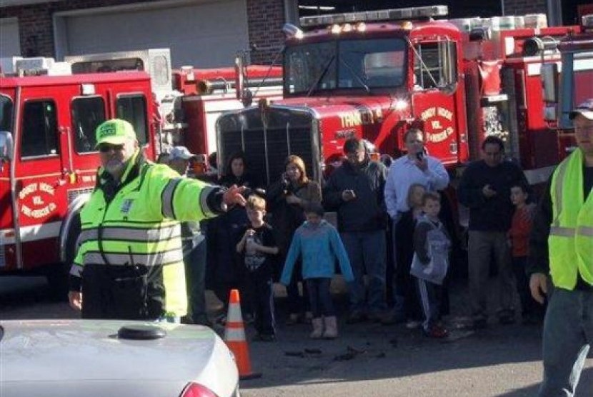 Para petugas tengah mengevakuasi siswa-siswa di the Sandy Hook Elementary School setelah aksi penembakan brutal di sana, di Connecticut, AS, Jumat (14/12) waktu setempat. 