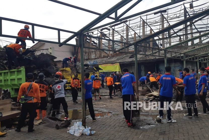 Para relawan bekerja bakti membersihkan Pasar Legi, Solo, Ahad (11/11). Merek membersihkan puing-puing bangunan pasar yang terbakar sekitar dua pekan lalu tersebut.