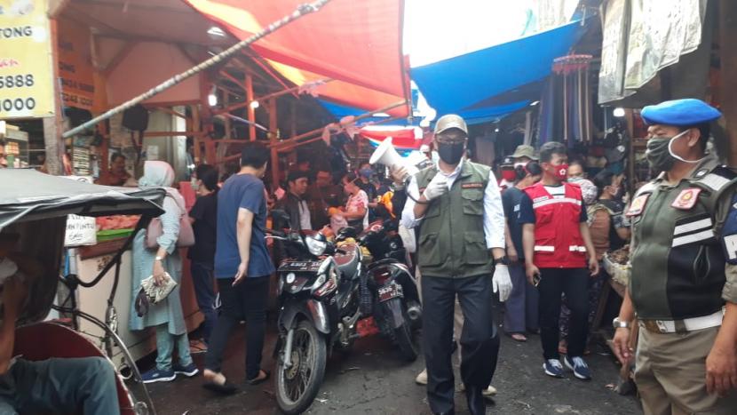 Para relawan dan Wali Kota Sukabumi Achmad Fahmi membagikan masker kepada warga dan pedagang yang berada di Gang Peda, Kota Sukabumi, Kamis (9/4).