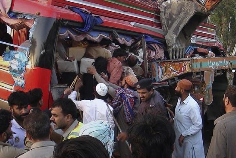 Para relawan dan warga bahu-membahu menyelamatkan penumpang bus yang mengalami kecelakaan di Pakistan.