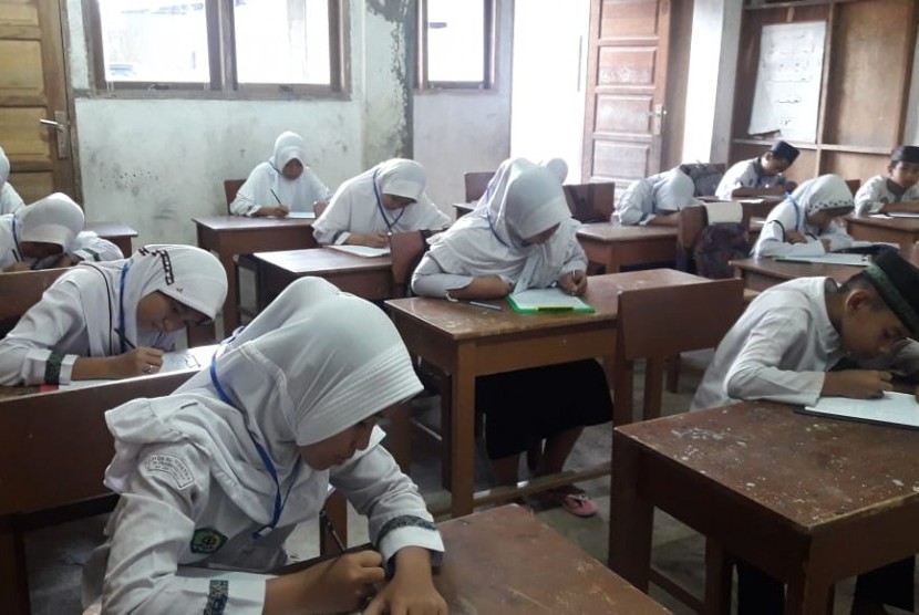 Para santri MDT Darul Hujaj Tabing, Koto Tangah, Padang, tengah mengikuti ujian nasional.