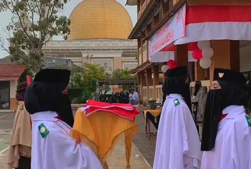 Para santri perempuan menjadi paskibra saat pelaksanaan upacara peringatan ke-78 Hari Ulang Tahun (HUT) Kemerdekaan Republik Indonesia di Pesantren Idrisiyyah, Kabupaten Tasikmalaya, Jawa Barat, Kamis (17/7/2023).   