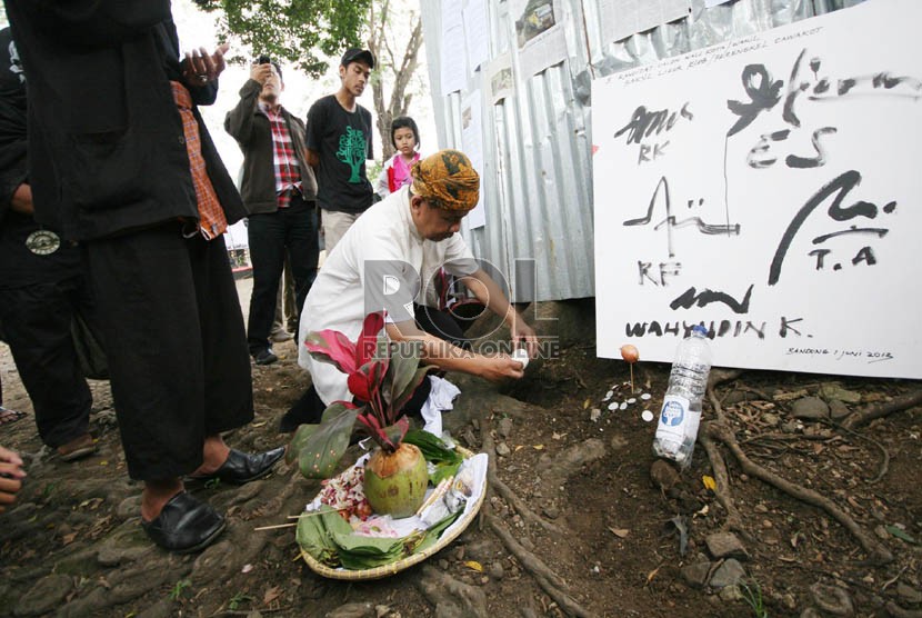 Para seniman Bandung melakukan aksi simbolik mengubur telur busuk sebagai simbol mengubur pikiran dan niat busuk di Hutan Kota Babakan Siliwangi (Baksil), Jl Siliwangi, Bandung, Rabu (5/6). (Republika/Edi Yusuf)