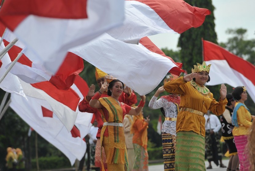 Para seniman menari dengan mengenakan pakaian adat dari berbagai daerah di Indonesia dalam kegiatan doa bersama Nusantara Bersatu di lapangan Margarana, Denpasar, Rabu (30/11).