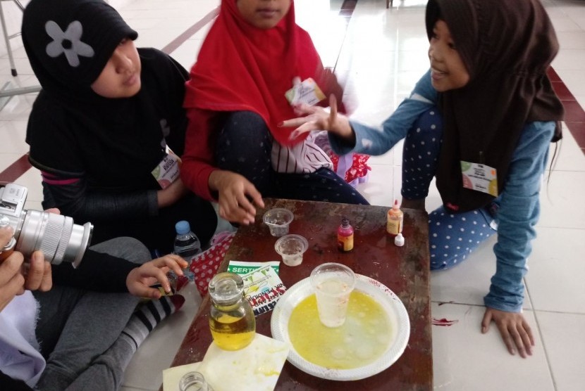 Para siswa antusias melakukan eksperimen massa jenis air dan minyak dalam acara Fun Science And Math di SD Muhammadiyah 5, Kebayoran Baru, Jakarta, Sabtu (17/2).  