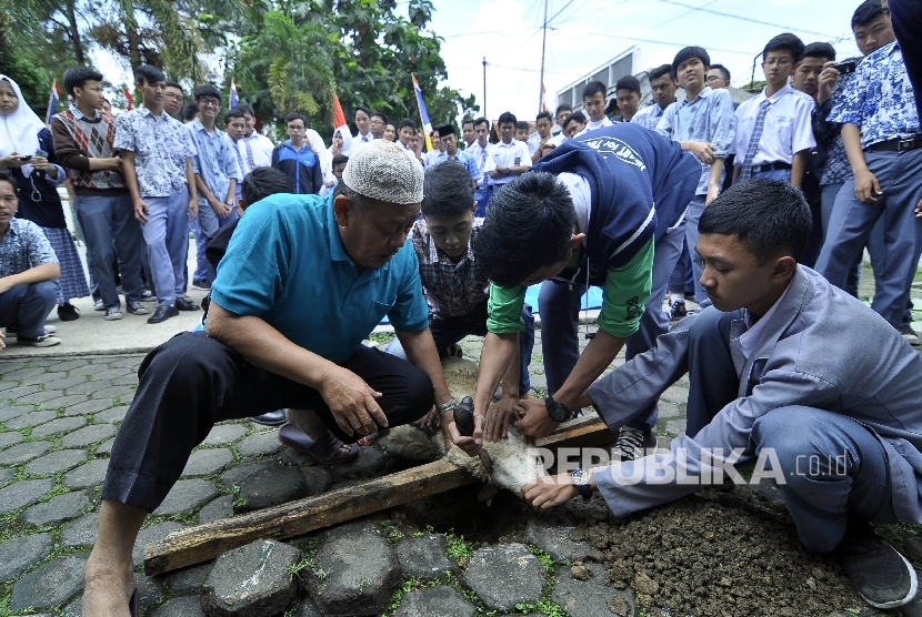 Para siswa mempraktikkan teori penyembelihan domba saat pelatihan tata cata penyembelihan hewan kurban di Sekolah Menengah Atas (SMA) Darul Hikam, Jl Tubagus Ismail, Kota Bandung (Ilustrasi) 