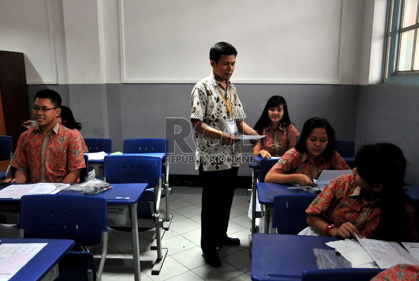   Pengawas mengumpulkan soal dan lembar jawaban para siswa usai mengikuti pelaksanaan ujian nasional (UN) hari terakhir di ruang kelas SMUN 1 Jakarta, Kamis (18/4).   (Republika/Prayogi)