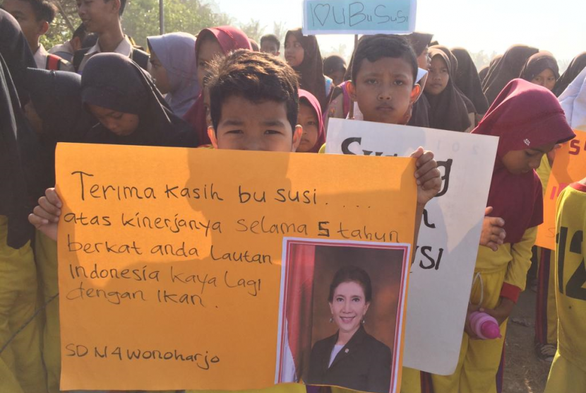 Para siswa meyambut kedatangan Susi Pudjiastuti di landasan pacu Pamugaran, Kecamatan Pangandaran, Kabupaten Pangandaran, Sabtu (26/10). 