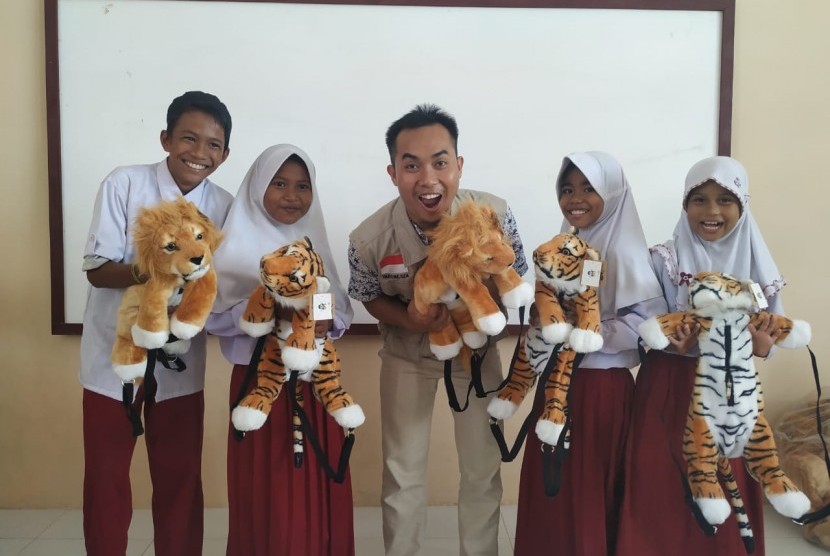 Para siswa SDN 21 Sindue-Donggala, Sulawesi Tengah menunjukkan kegembiraan mereka sambil memegang boneka harimau.
