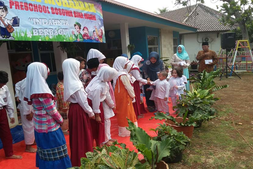 Para siswa TK Bina Insani Bogor menyerahkan bingkisan kepada anak-anak yatim.