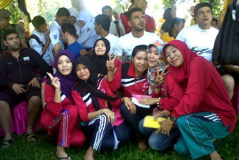 Para siswi mengerubungi atlet Iran pada Musi Triboatton 2014 di Kabupaten Empat Lawang, Sumatera Selatan (25/11)
