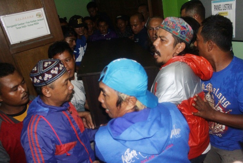 Para suporter Arema membantu membawa peti jenazah penjaga gawang Arema, Achmad Kurniawan, di ruang jenazah Rumah Sakit Syaiful Anwar, Malang, Jawa Timur, Selasa (10/1).