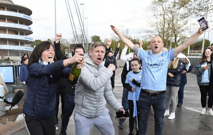 Para suporter Manchester City merayakan gelar juara tim kesayangan mereka di luar Stadion Etihad, Manchester.