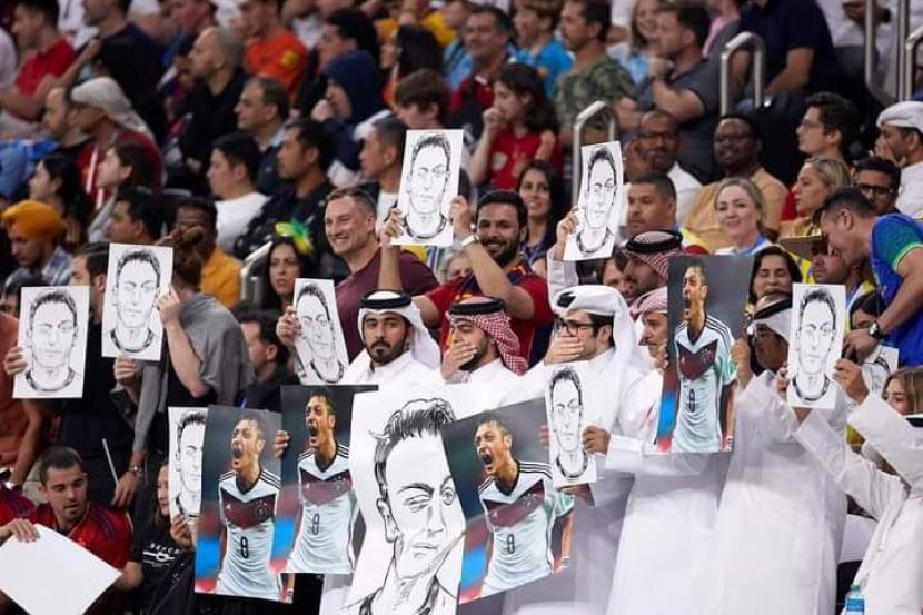 Para suporter Qatar membawa poster Mesut Oezil untuk menyindir pemain timnas Jerman.