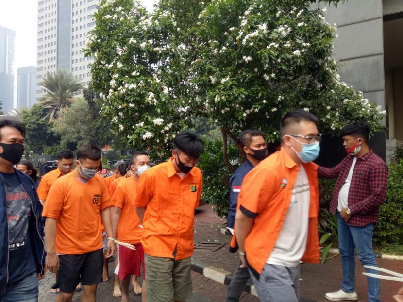 Para tersangka (baju oranye) penyelenggara pesta seks sesama jenis atau gay di Kuningan, Jakarta Selatan beserta barang bukti saat konferensi pers di Mapolda Metro Jaya, Rabu (2/9).
