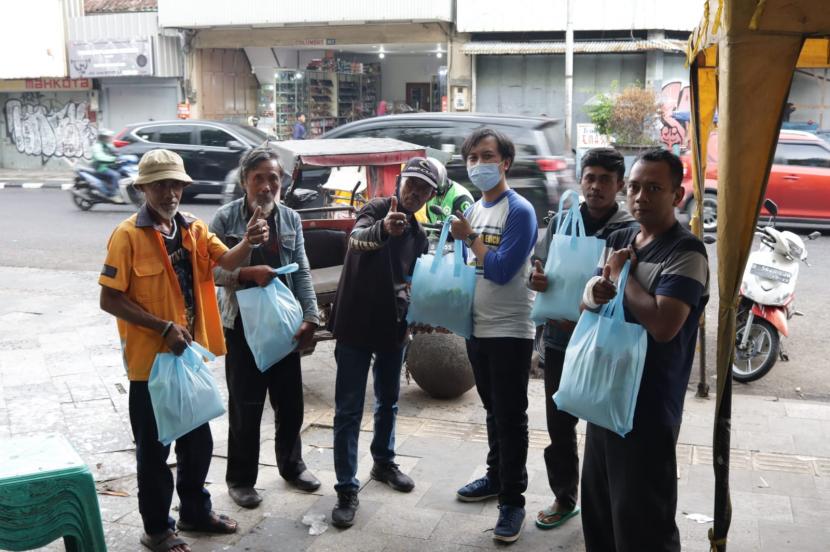 Para tukang becak, pedangang kaki lima dan tukang parkir di kawasan Pasar Kosambi Kota Bandung menerima bantuan paket sembako dari Relawan Baik.