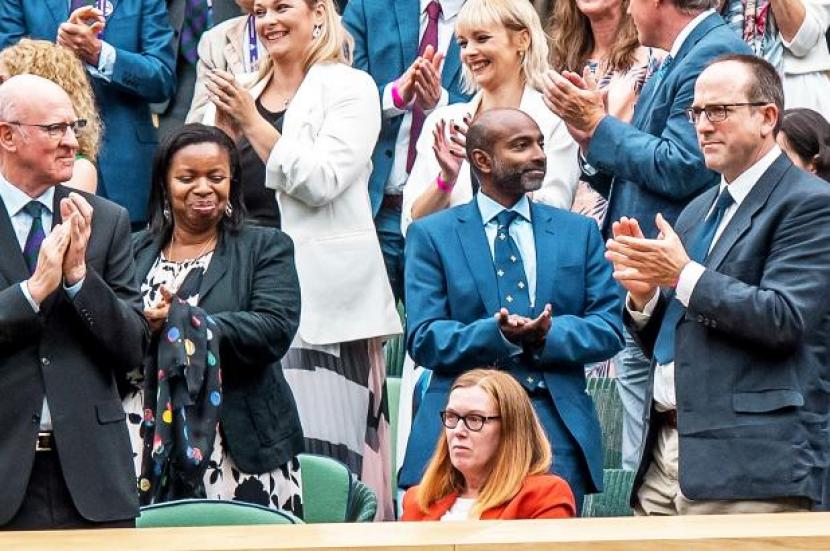 Para undangan VVIP dan anggota kerajaan Inggris yang berada The Royal Box stadion tenis Wambley, London berdiri dan bertepuk tangan memberi pujian kepada Ilmuwan Universitas Oxford dan ilmuwan Astrazeneca Profesor Sarah Gilbert (duduk dengan warna merah). 