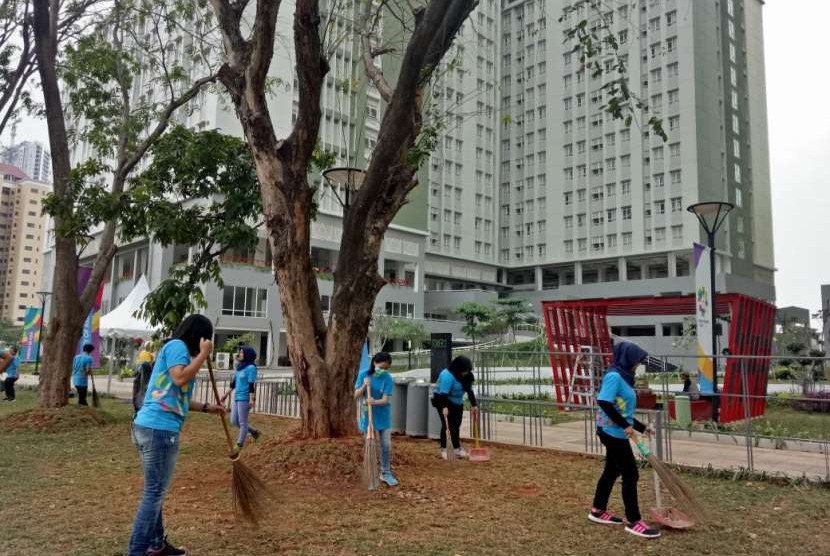 Para volunteer Asian Games 2018, tengah sibuk membersihkan taman di Wisma Atlet, Kemayoran, Selasa (7/8) sore. 