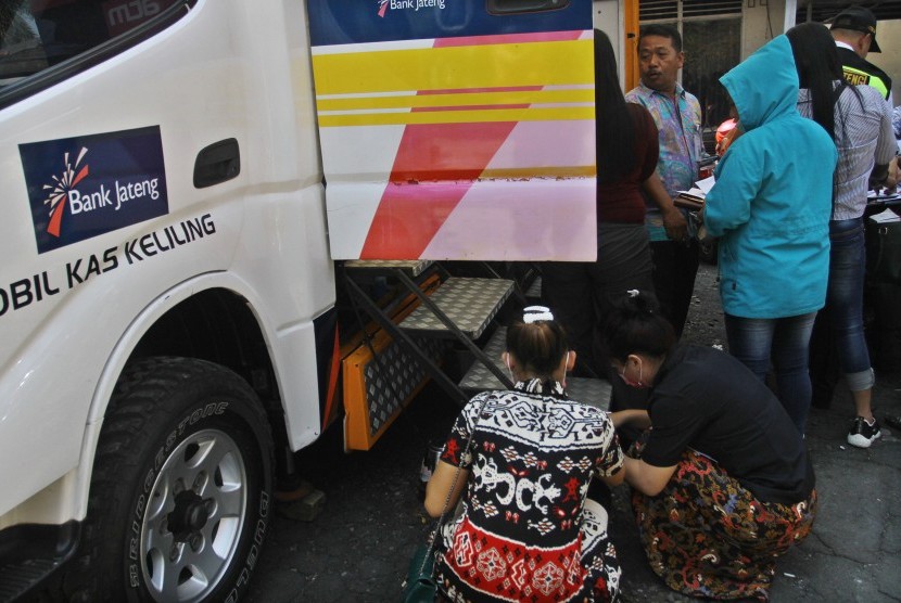   Para wanita eks penghuni Resosialisasi Argorejo, mencairkan tali asih di mobil kas keliling bank Jateng, usai acara penutupan secara resmi lokalisasi yang ada di wilayah Kelurahan Kalibanteng, Kecamatan Semarang Barat, Kota Semarang, Jumat (18/0). 