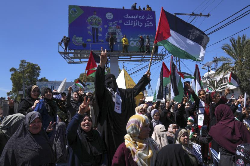 Para wanita mengibarkan bendera Palestina dan meneriakkan slogan-slogan selama rapat umum solidaritas dengan penduduk Palestina di Tepi Barat dan Yerusalem, di Kota Gaza, Jumat, 15 April 2022.
