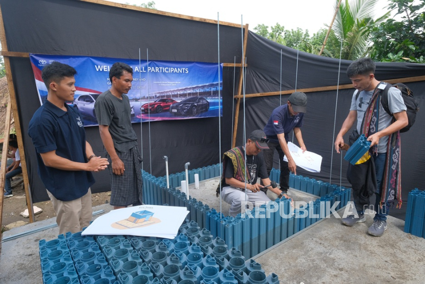 Para wartawan berpartisipasi dalam pembangunan toilet umum yang diinisiasi oleh Toyota di Desa Wisata Sasak Ende, Lombok Tengah, Kamis (3/12/2025) menggunakan bata daur ulang sampah plastik buatan Block Solutions Indonesia.