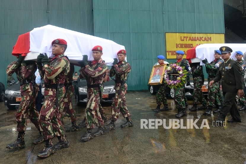 Parajurit TNI dan Polri membawa peti ke dalam Mobil Jenazah saat upacara pelepasan jenazah korban Helikopter TNI AD jenis Bell 412 EP di Hanggar Skadron Udara 17 Lanud Halim Perdanakusuma, Jakarta, Selasa (22/3).