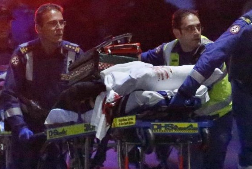 Paramedics remove a person, with bloodstains on the blankets covering the person, on a stretcher from the Lindt cafe, where hostages were being held, at Martin Place in central Sydney December 16, 2014.